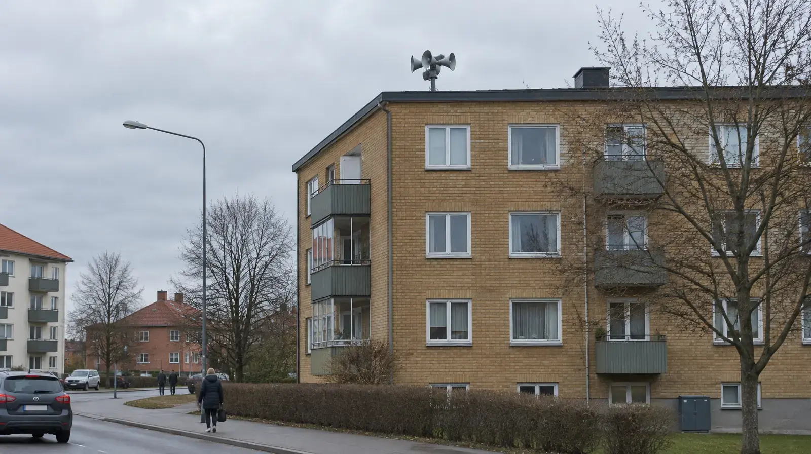 Utomhussignal för viktigt meddelande till allmänheten, högtalare på en stolpe på taket till ett flerbostadshus.